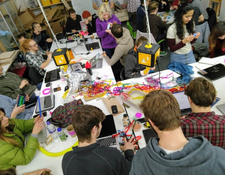 A group of Falmouth University students around a table with string and objects