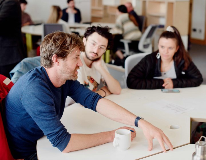 Staff and students talking around a table