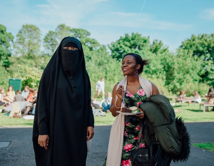 Falmouth student wearing burkha chatting with another student at an international event.