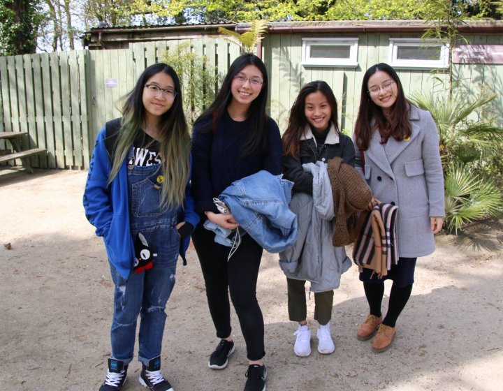 Group of female Asian students smiling at the camera.