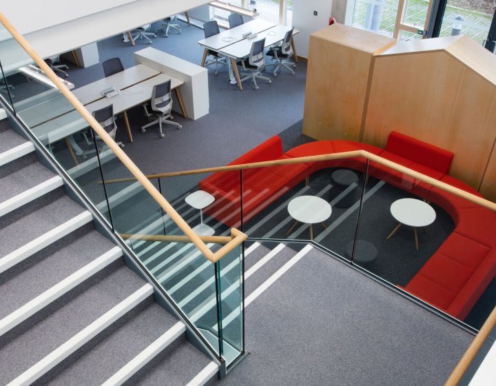 Looking down the staircase at Launchpad with a red sofa and desks