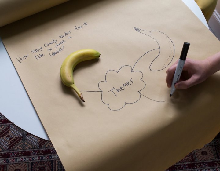 A large brown roll of paper with themes written in the centre and a banana