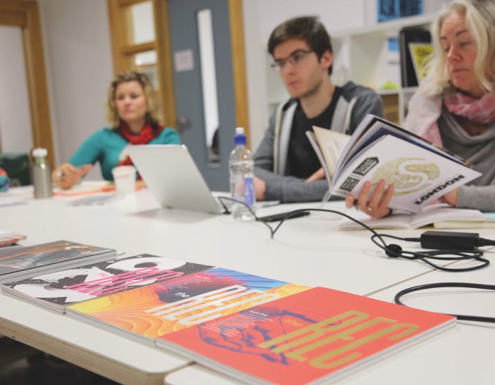 Falmouth University MA Graphic Design students at a table