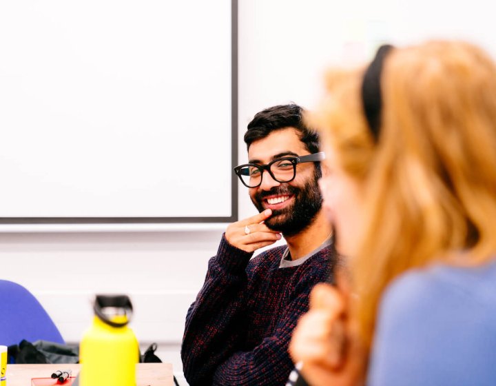 Two students sat together discussing Illustration