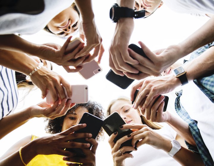 Young people using their phones in a circle
