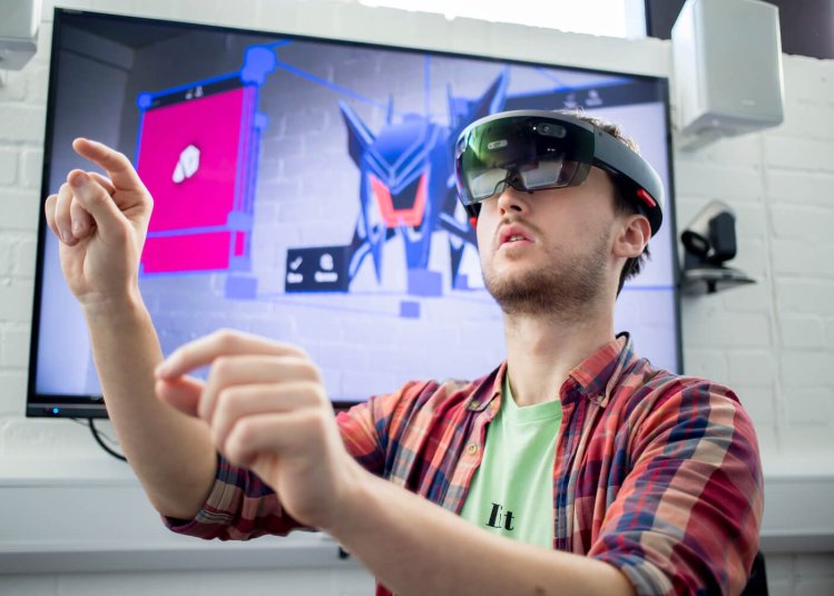 A Falmouth University student wearing a VR headset and a checked shirt