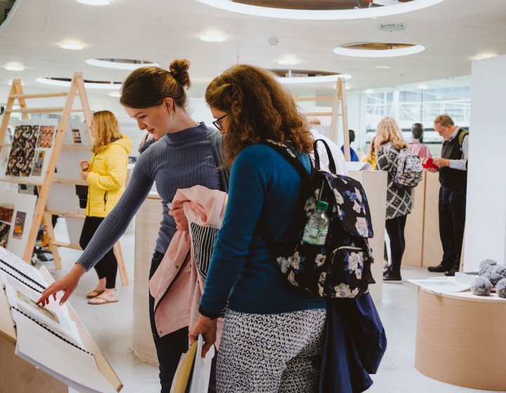 Mother and daughter at a Falmouth University open day looking at art work.