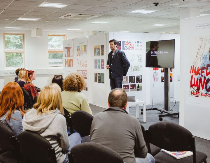 Falmouth University Illustration lecturer talking to group of prospective students and parents.