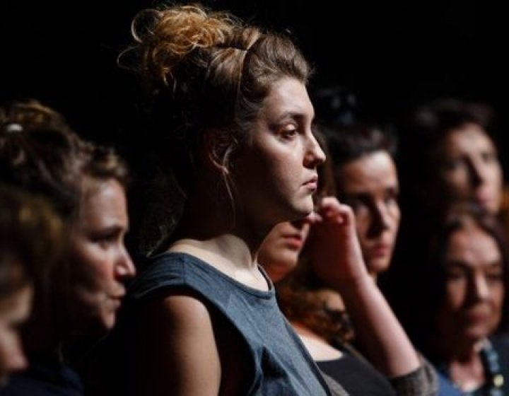 a group of young women standing in dark light