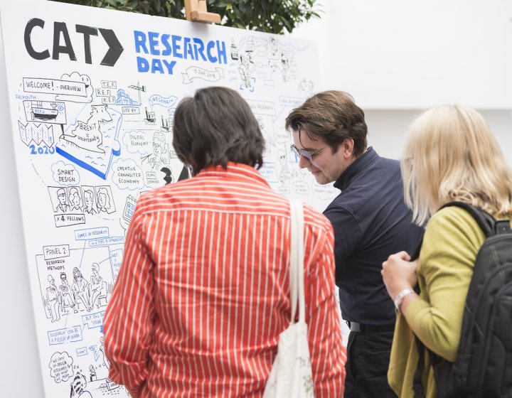 Two men and a woman at a whiteboard