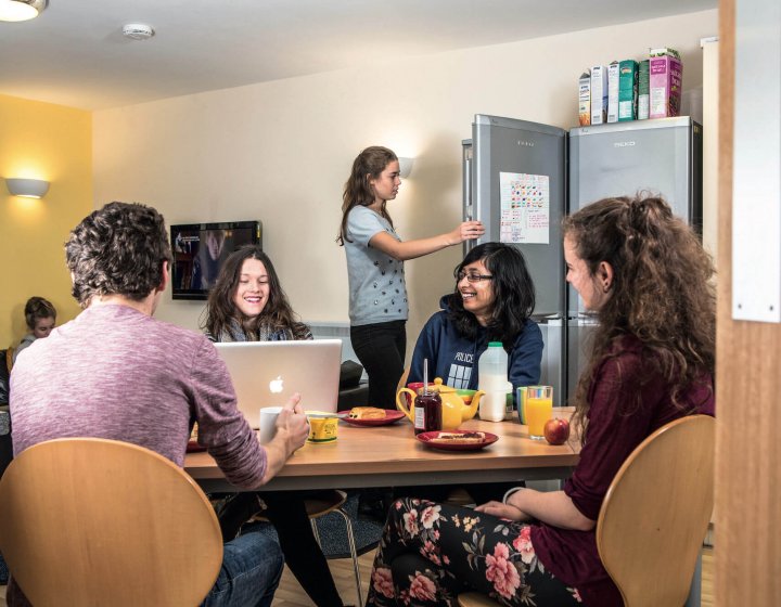 A group of Falmouth University students sat round a table having breakfast in university halls