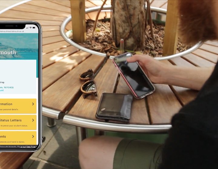 Mobile phone displaying Falmouth app and Student using his phone in the background.