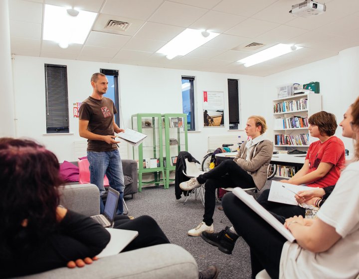 A Falmouth University student stood up presenting to other students in a seminar