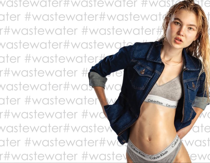 A woman in Calvin Klein grey underwear and a denim jacket with #wastewater text in the background