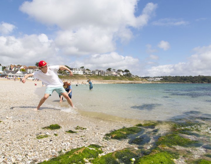 Falmouth University students throwing stones on the shore