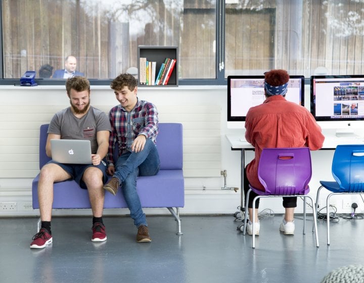 Business students looking at laptop together