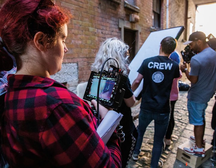 A group of Television students on a television production set with a camera