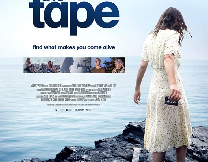 Film poster for 'The Tape'. A woman in a white dress with her back to us, a guitar at her feet.