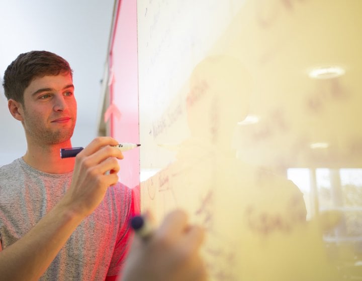 Falmouth student at a whiteboard