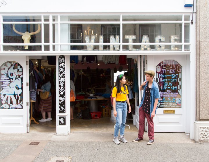 Students stood outside a shop with Vintage letter lights in the window.