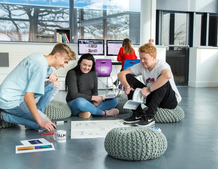 Falmouth University Business students sat on the floor looking through work.