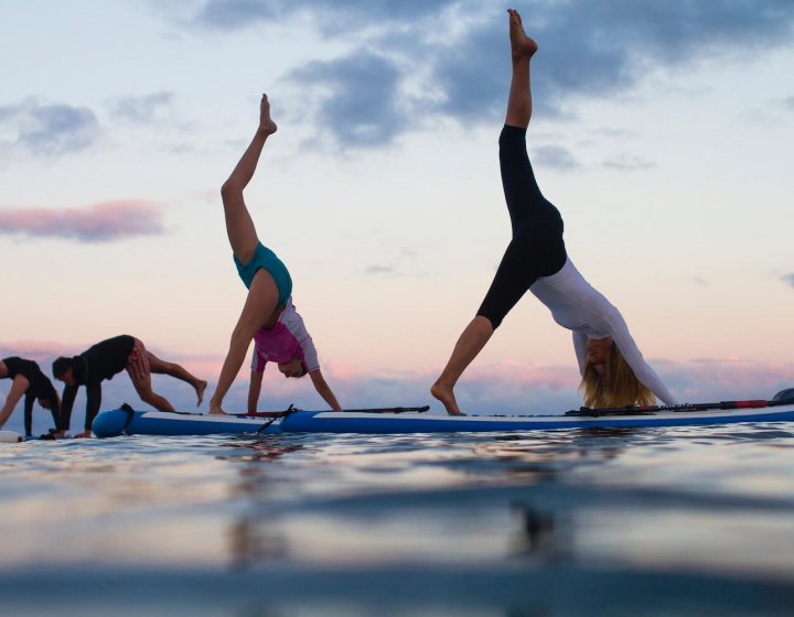 Falmouth University students doing yoga on paddle boards