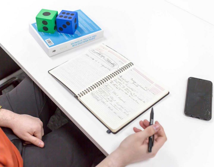 A student doing data calculations in a notebook
