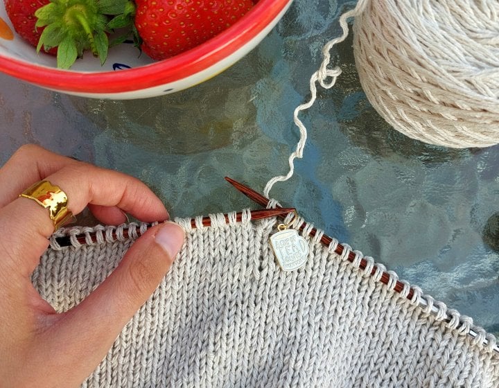 A bird's eye shot of some knitting and a bowl of strawberries