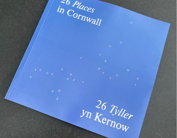 Photo of 26 Cornwall book - light blue cover with A-Z of letters scattered in the shape of Cornwall  in white. Title reads: 26 places Cornwall / 26 Tyller yn Kernow
