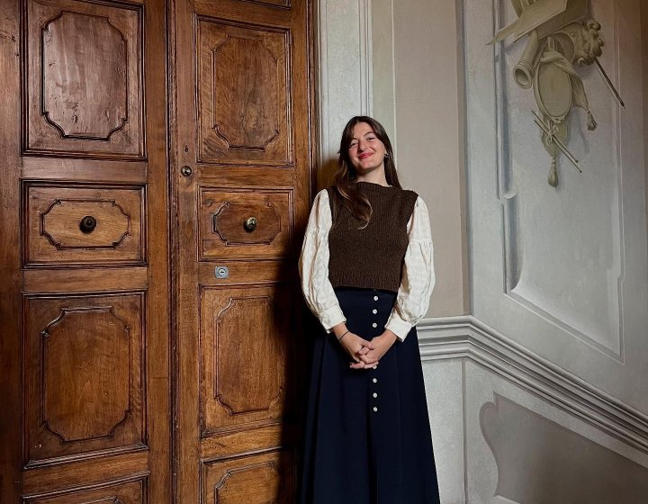 A woman stood in front of a large wooden door