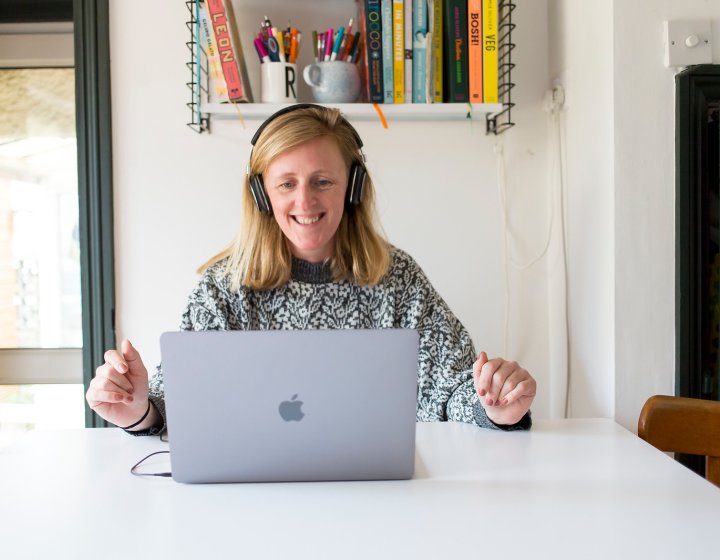 A woman smiling while looking at her laptop