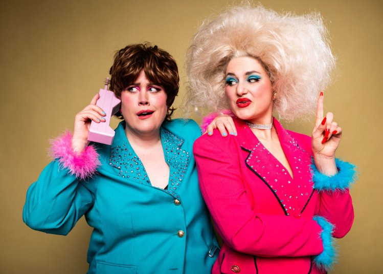 Two brightly coloured dressed people posing for the camera
