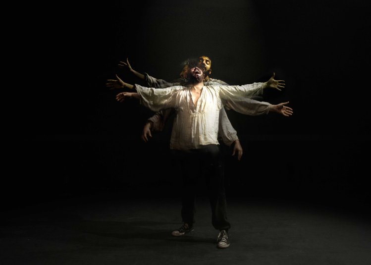 A person in the centre of the image with their arms spread out widely screaming