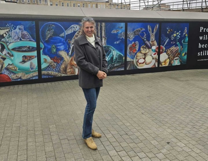 Artist and student Cindy Powell stood next to her mural of wildlife at Paddington station in London