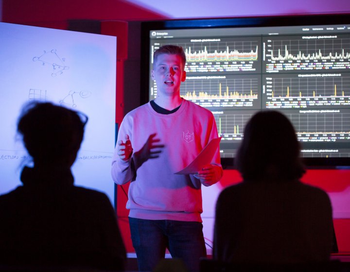 A student giving a presentation on coding
