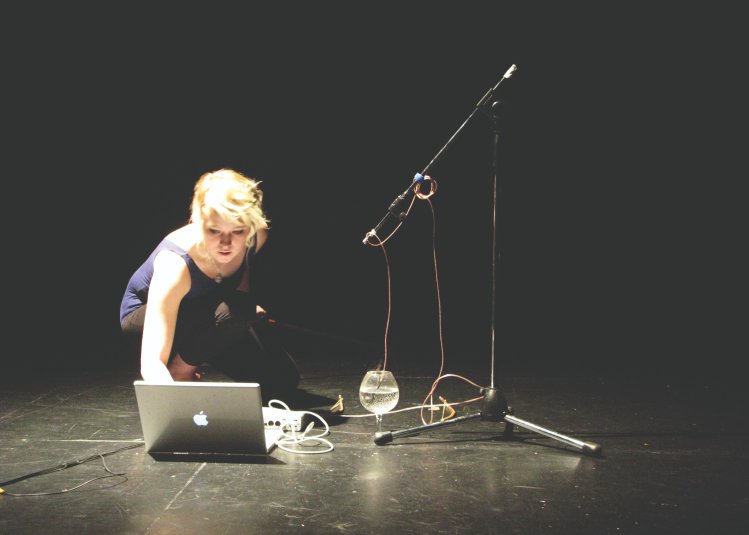 Student on sound stage recording sound from a glass at Falmouth University