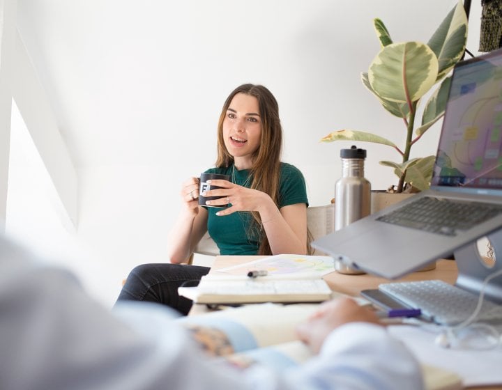 Person sat at table next to laptop talking