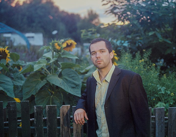 Benjamin Woods of band The Golden Dregs leaning on a fence 