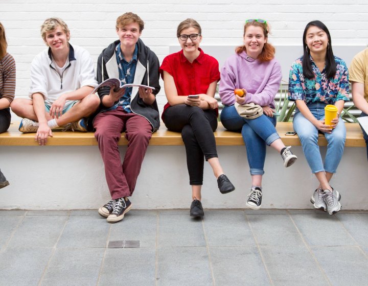 Students sitting on a wall