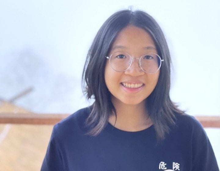 Photo of girl wearing round glasses and navy blue t-shirt