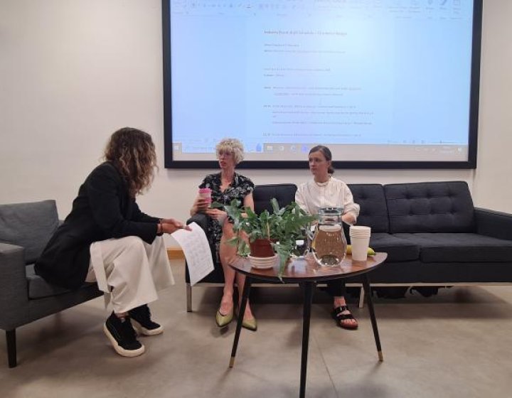 An Interior Design student sitting on a sofa with a lecturer and industry partner
