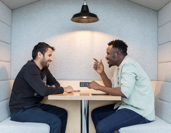 Two students talking across a table at Falmouth University 