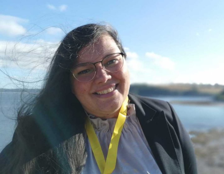 Dr Sherezade García Rangel standing in front of a lake 