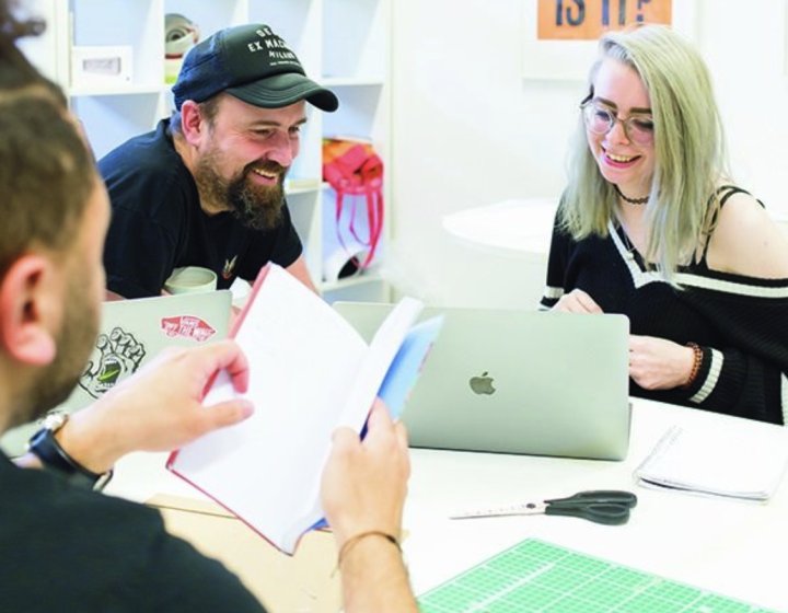 Creative advertising students discussing work