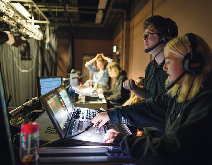Two people sitting at a theatre tech desk working