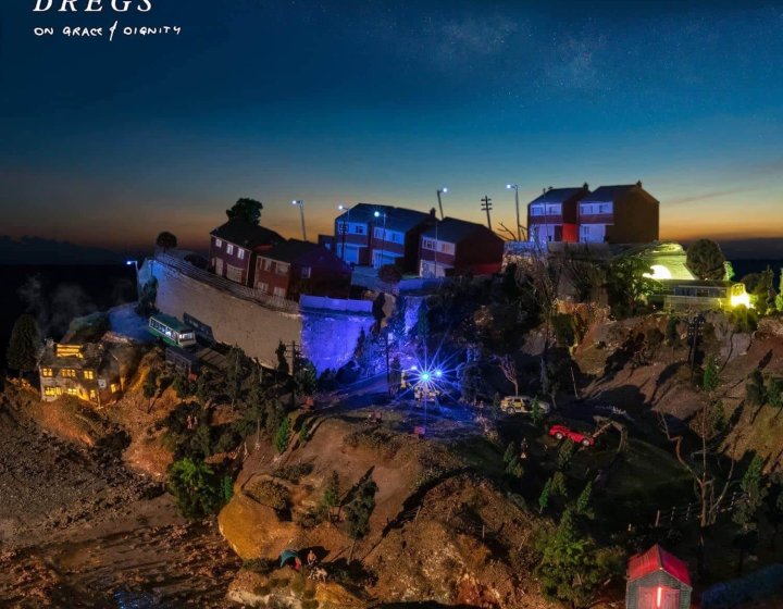 Album cover of houses on muddy cliffs at night