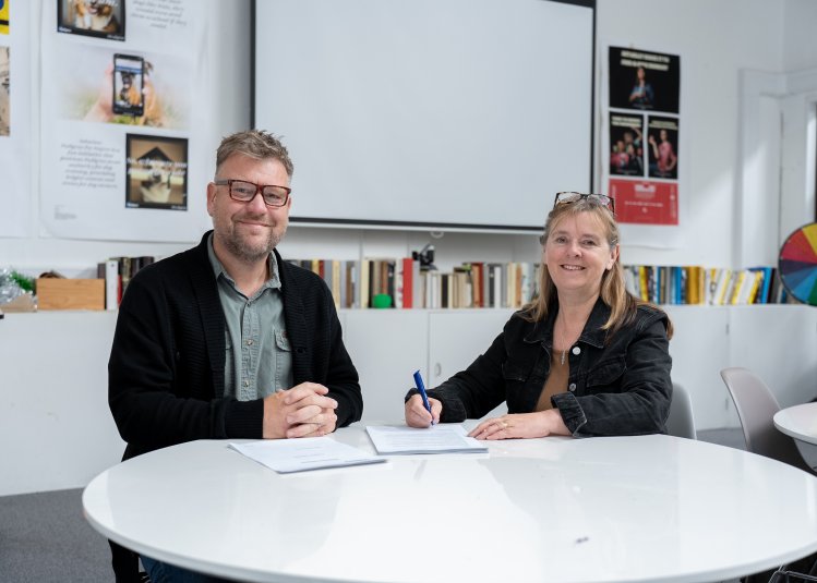 Two people signing an agreement