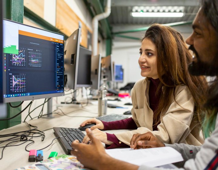 Two AI for Games students at a computer at Falmouth University