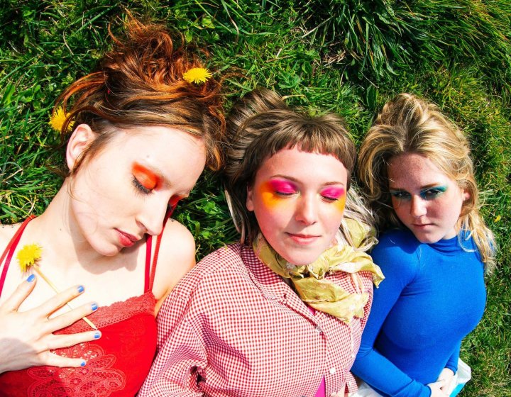 Three women wearing colourful clothes