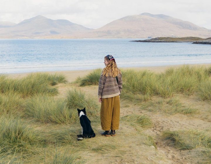 Woman and dog looking out to sea